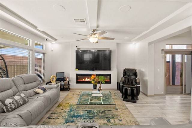 8955 Ruby Moon Dr, Las Vegas, NV 89139 - living room featuring a glass covered fireplace, a ceiling fan, and light wood finished floors