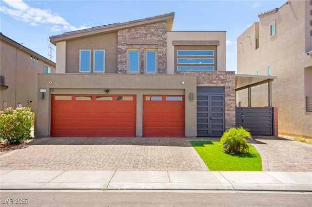 8955 Ruby Moon Dr, Las Vegas, NV 89139 - view of front of property with decorative driveway, an attached garage, stucco siding, and stone siding