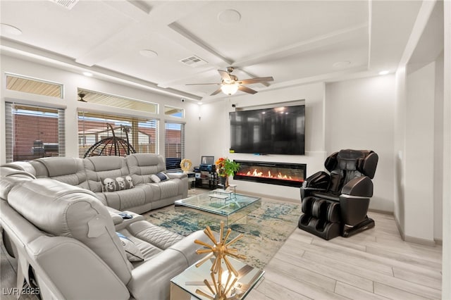 8955 Ruby Moon Dr, Las Vegas, NV 89139 - living area with wood finished floors, a glass covered fireplace, ceiling fan, and coffered ceiling