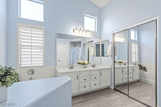 5108 Molveno Ct, Las Vegas, NV 89130 - bathroom with plenty of natural light, double vanity, a bathtub, and high vaulted ceiling