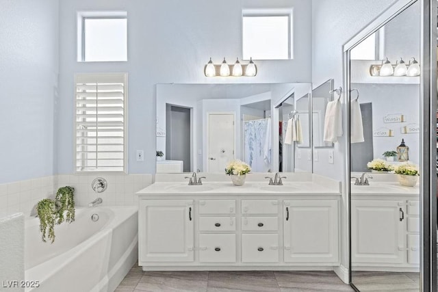 5108 Molveno Ct, Las Vegas, NV 89130 - full bathroom with double vanity, a bath, a towering ceiling, and plenty of natural light