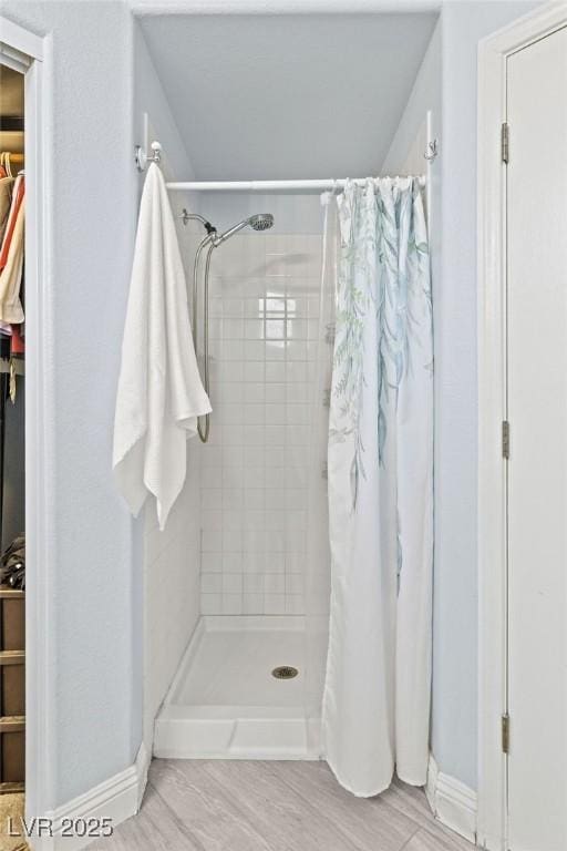 5108 Molveno Ct, Las Vegas, NV 89130 - full bathroom featuring a stall shower, a spacious closet, and wood finished floors