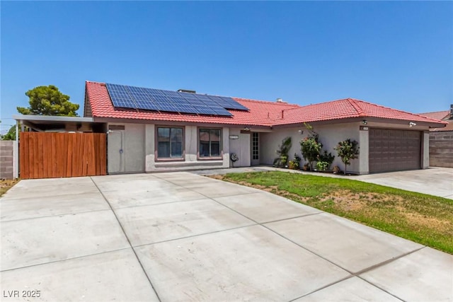 5734 Duval Dr, Las Vegas, NV 89156 - single story home featuring driveway, stucco siding, a tile roof, a garage, and solar panels