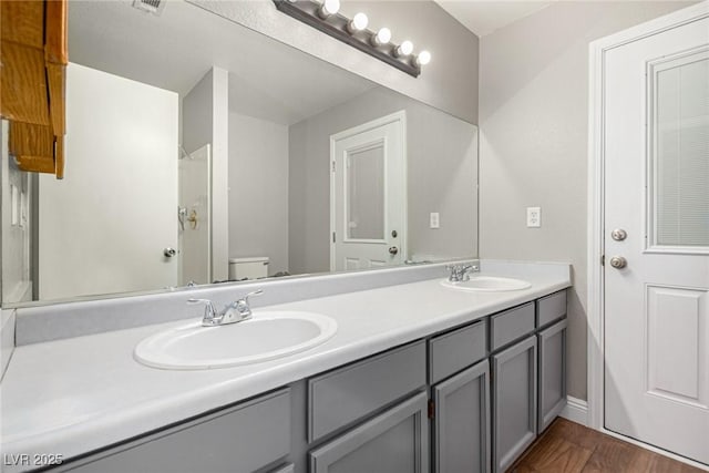 5734 Duval Dr, Las Vegas, NV 89156 - bathroom featuring double vanity, wood finished floors, and a shower