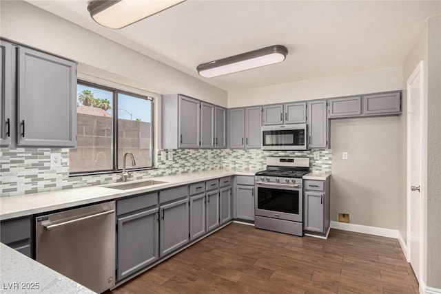 5734 Duval Dr, Las Vegas, NV 89156 - kitchen featuring stainless steel appliances, gray cabinetry, backsplash, dark wood-style floors, and light countertops