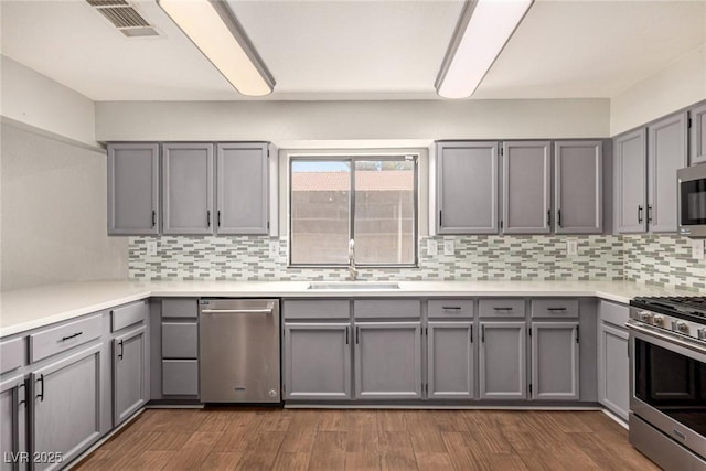 5734 Duval Dr, Las Vegas, NV 89156 - kitchen featuring appliances with stainless steel finishes, gray cabinets, and backsplash