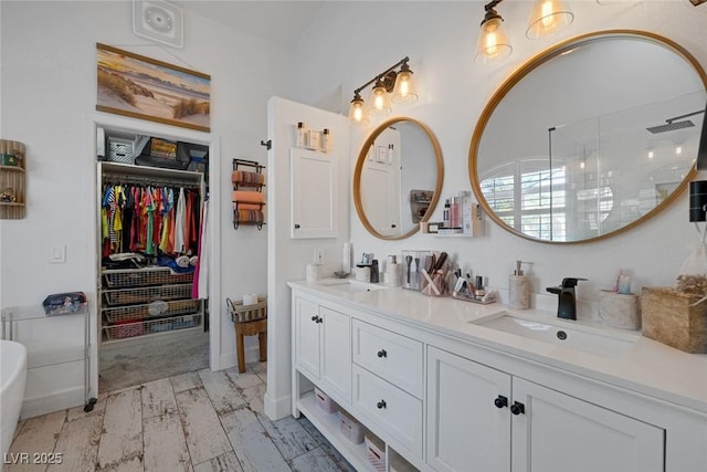 1246 Diamond Valley St, Henderson, NV 89052 - bathroom with double vanity, a spacious closet, tiled shower, wood finished floors, and a freestanding bath