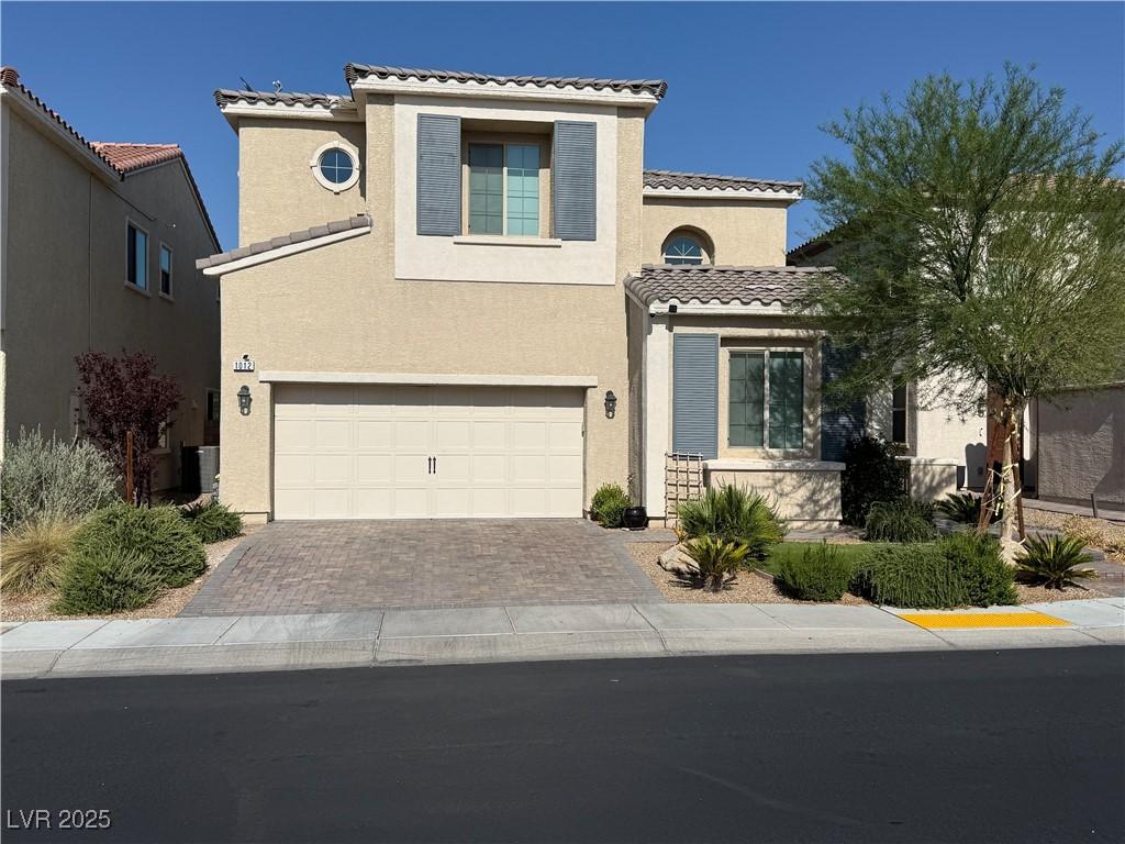 1012 Via Stellato St, Henderson, NV 89011 - mediterranean / spanish-style house with a tiled roof, stucco siding, an attached garage, and driveway