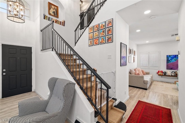 9105 Chenin Ave, Las Vegas, NV 89129 - staircase with wood finished floors, a chandelier, a high ceiling, and recessed lighting