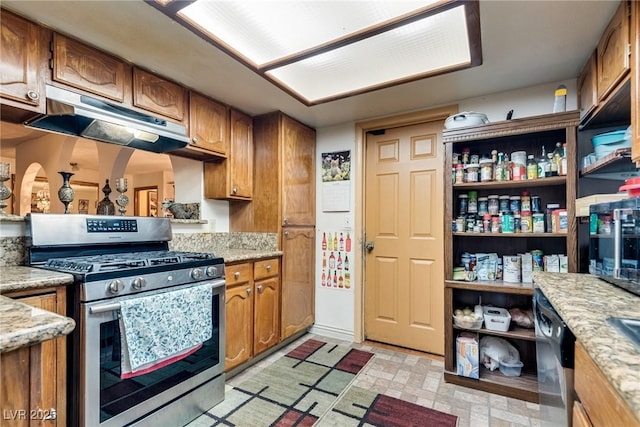 3877 Platis Cir, Las Vegas, NV 89103 - kitchen with stainless steel gas stove, under cabinet range hood, brown cabinets, and dishwasher