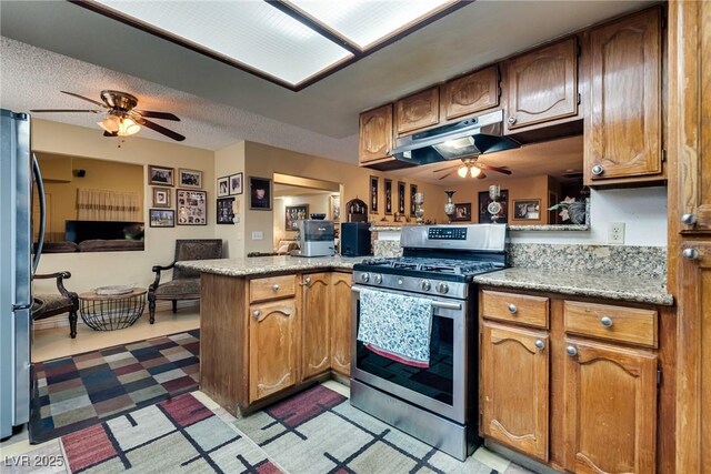 3877 Platis Cir, Las Vegas, NV 89103 - kitchen with appliances with stainless steel finishes, ceiling fan, a peninsula, under cabinet range hood, and light countertops