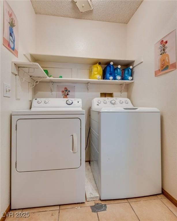 3877 Platis Cir, Las Vegas, NV 89103 - washroom with washing machine and dryer, a textured ceiling, and light tile patterned floors