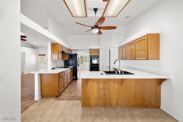 170 Dove St, Pahrump, NV 89060 - kitchen featuring a ceiling fan, a peninsula, black appliances, light countertops, and high vaulted ceiling