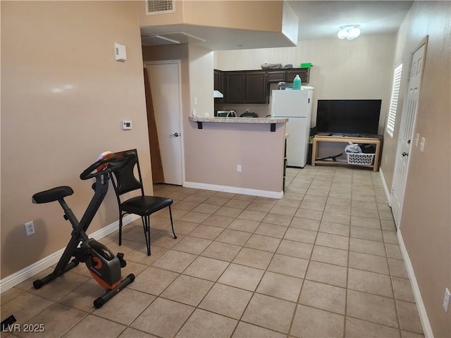 2110 Los Feliz St Unit 1096, Las Vegas, NV 89156 - kitchen featuring freestanding refrigerator, a peninsula, and light tile patterned floors