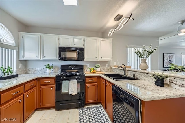 3125 N Buffalo Dr Unit 1133, Las Vegas, NV 89128 - kitchen featuring black appliances, a peninsula, white cabinets, light stone counters, and light tile patterned flooring