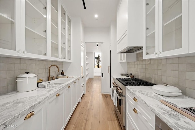 68 Sun Glow Ln, Las Vegas, NV 89135 - kitchen with stainless steel stove, white cabinetry, glass insert cabinets, light wood-style floors, and recessed lighting