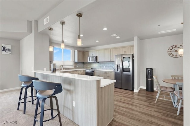 8255 Las Vegas Blvd Unit 722, Las Vegas, NV 89123 - kitchen with stainless steel appliances, a peninsula, a kitchen breakfast bar, light countertops, and recessed lighting