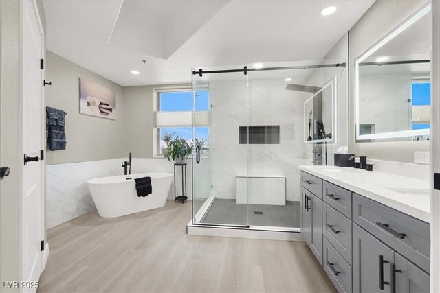 8255 Las Vegas Blvd Unit 722, Las Vegas, NV 89123 - bathroom featuring wood finished floors, double vanity, a soaking tub, a marble finish shower, and recessed lighting
