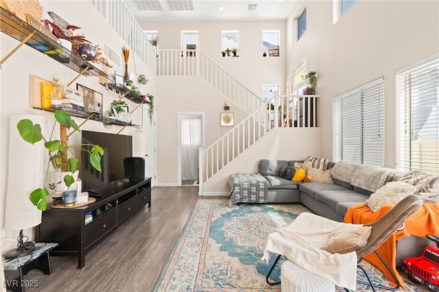 5674 Moccasin Point St, Las Vegas, NV 89148 - living room featuring stairs, a towering ceiling, wood finished floors, and healthy amount of natural light