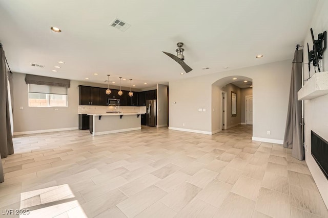 8048 Skye Bridge St, Las Vegas, NV 89166 - unfurnished living room featuring a ceiling fan, arched walkways, and recessed lighting