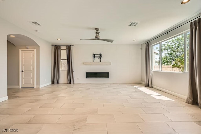 8048 Skye Bridge St, Las Vegas, NV 89166 - unfurnished living room featuring a ceiling fan, arched walkways, recessed lighting, and a glass covered fireplace