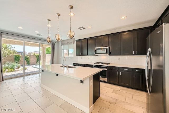 8048 Skye Bridge St, Las Vegas, NV 89166 - kitchen featuring stainless steel appliances, light countertops, tasteful backsplash, an island with sink, and recessed lighting