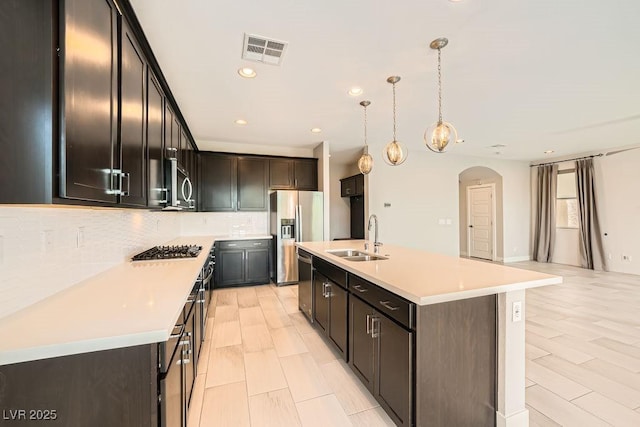 8048 Skye Bridge St, Las Vegas, NV 89166 - kitchen with stainless steel appliances, arched walkways, tasteful backsplash, light countertops, and recessed lighting