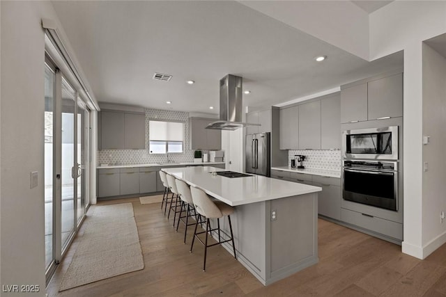 9789 Twilight Moon Ave, Las Vegas, NV 89148 - kitchen featuring gray cabinets, stainless steel appliances, island range hood, backsplash, and recessed lighting
