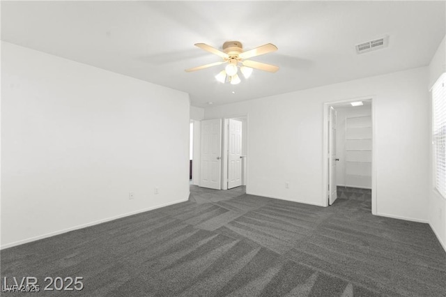 11755 Garland Grove Ln, Las Vegas, NV 89183 - unfurnished bedroom featuring dark carpet, a walk in closet, and ceiling fan