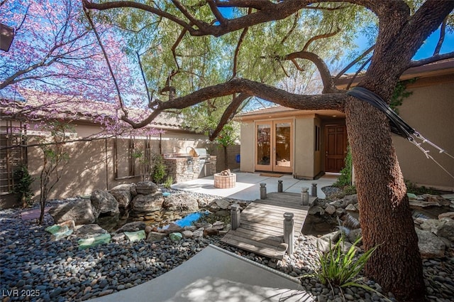 15 Emerald Dunes Cir, Henderson, NV 89052 - view of patio with french doors, an outdoor kitchen, and a garden pond