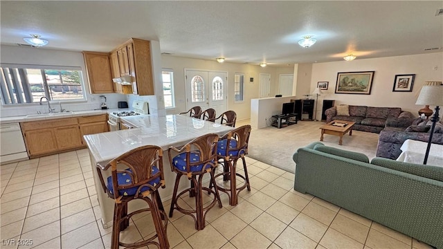 3110 National Ave, Pahrump, NV 89048 - kitchen featuring tile countertops, white appliances, open floor plan, light tile patterned flooring, and healthy amount of natural light