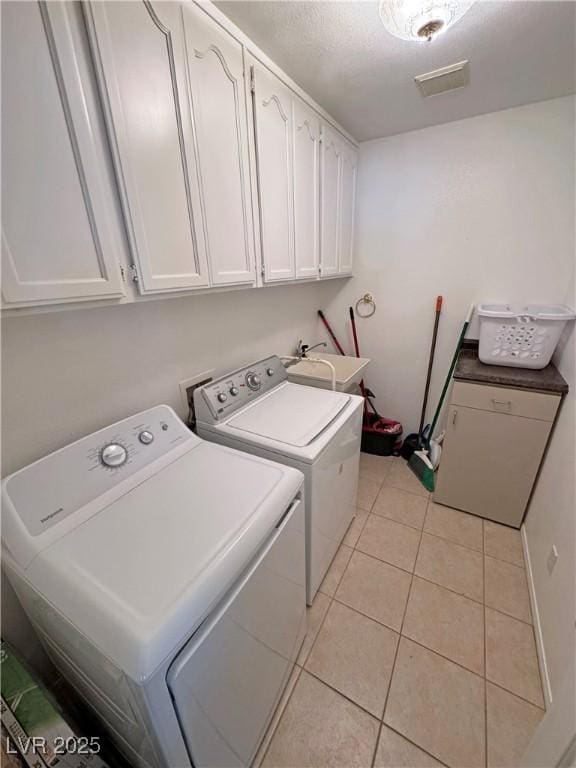 3110 National Ave, Pahrump, NV 89048 - laundry area with washer and clothes dryer, cabinet space, and light tile patterned flooring