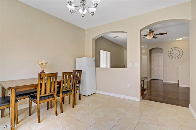 4020 Smokey Fog Ave Unit 102, North Las Vegas, NV 89081 - dining room featuring arched walkways, a ceiling fan, a chandelier, and light tile patterned floors