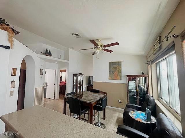 4314 Flaming Ridge Trl, Las Vegas, NV 89147 - dining room featuring arched walkways, ceiling fan, and light tile patterned flooring