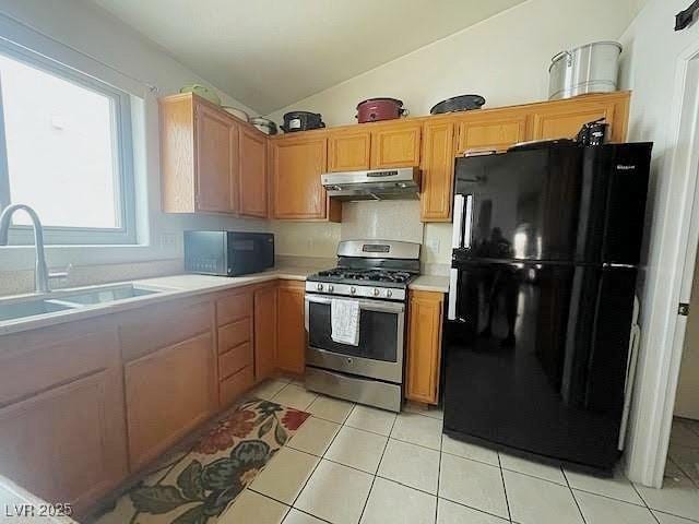 4314 Flaming Ridge Trl, Las Vegas, NV 89147 - kitchen featuring black appliances, under cabinet range hood, light countertops, lofted ceiling, and light tile patterned floors