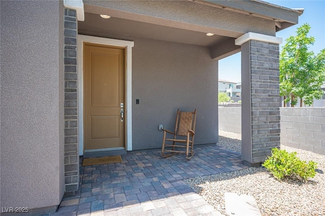 9451 Lunar Ray St, Las Vegas, NV 89143 - view of exterior entry with stucco siding and a patio area