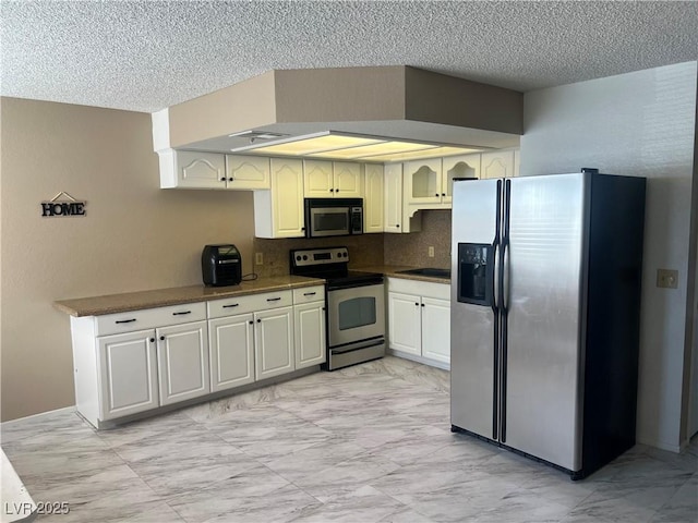 901 Sulphur Springs Ln Unit 101, Las Vegas, NV 89128 - kitchen featuring appliances with stainless steel finishes, light marble finish floors, a textured ceiling, dark countertops, and backsplash
