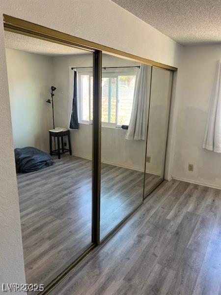 901 Sulphur Springs Ln Unit 101, Las Vegas, NV 89128 - unfurnished bedroom featuring a textured ceiling, wood finished floors, and a closet