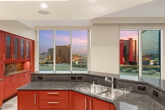 2747 Paradise Rd Unit 2704, Las Vegas, NV 89109 - kitchen with dark stone countertops, glass insert cabinets, and crown molding