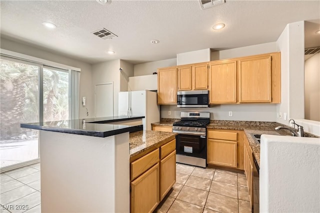 5021 Ropers Rock Ct, Las Vegas, NV 89131 - kitchen with appliances with stainless steel finishes, light tile patterned flooring, light brown cabinetry, a center island, and recessed lighting