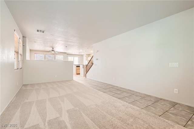5021 Ropers Rock Ct, Las Vegas, NV 89131 - unfurnished living room featuring ceiling fan, light tile patterned floors, stairs, and light colored carpet