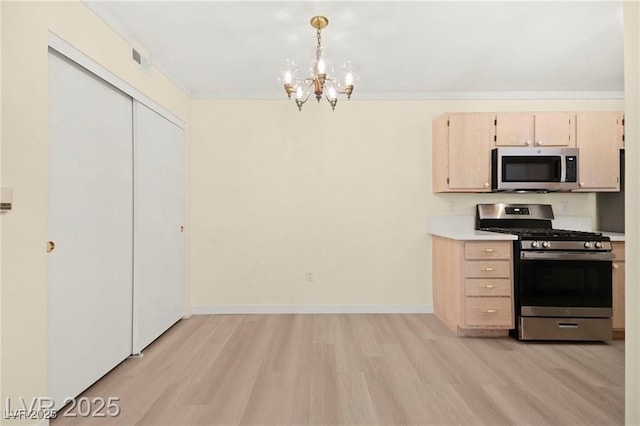 7885 W Flamingo Rd Unit 1131, Las Vegas, NV 89147 - kitchen with stainless steel appliances, light wood finished floors, a chandelier, light countertops, and hanging light fixtures