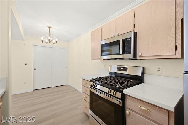 7885 W Flamingo Rd Unit 1131, Las Vegas, NV 89147 - kitchen featuring stainless steel appliances, a chandelier, light countertops, light wood-type flooring, and ornamental molding