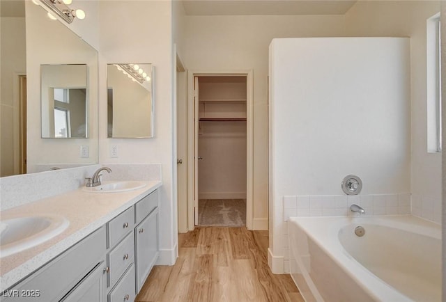 1716 Klamath Falls Way, Las Vegas, NV 89128 - full bathroom with a bath, double vanity, a walk in closet, and wood finished floors