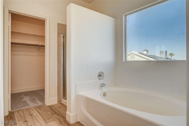 1716 Klamath Falls Way, Las Vegas, NV 89128 - bathroom featuring a bath, a walk in closet, a stall shower, and wood finished floors