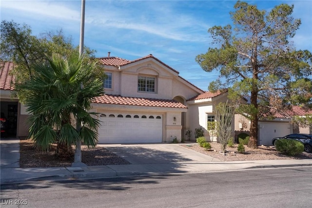 1910 Coyote Pass Way, Henderson, NV 89012 - mediterranean / spanish-style house featuring a tile roof, driveway, stucco siding, and a garage