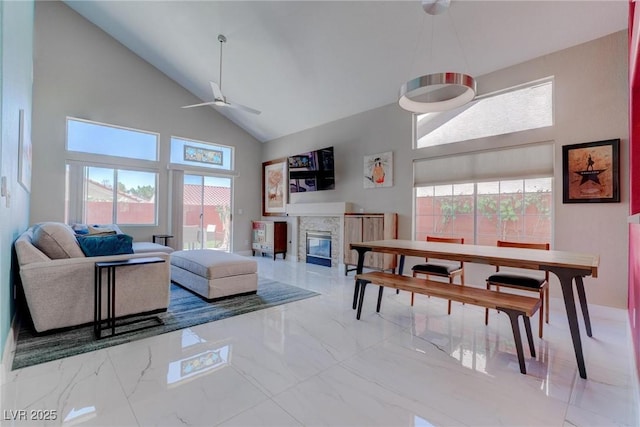1910 Coyote Pass Way, Henderson, NV 89012 - living room with high vaulted ceiling, a ceiling fan, a glass covered fireplace, and marble finish flooring