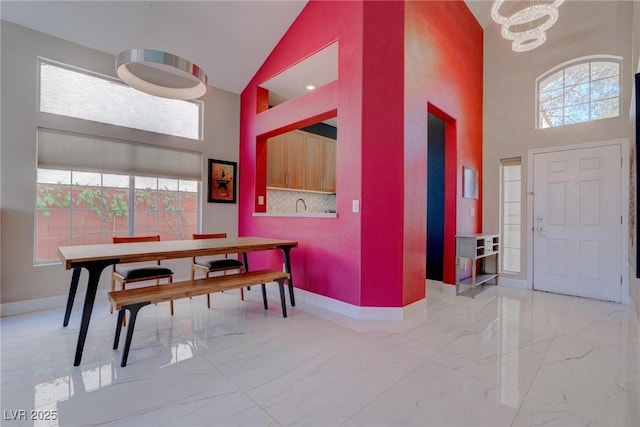 1910 Coyote Pass Way, Henderson, NV 89012 - dining area with high vaulted ceiling, a chandelier, and marble tiled flooring