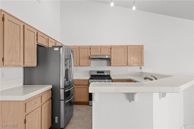 920 Serpentina Ave, Las Vegas, NV 89123 - kitchen featuring appliances with stainless steel finishes, a peninsula, under cabinet range hood, light tile patterned flooring, and tile countertops