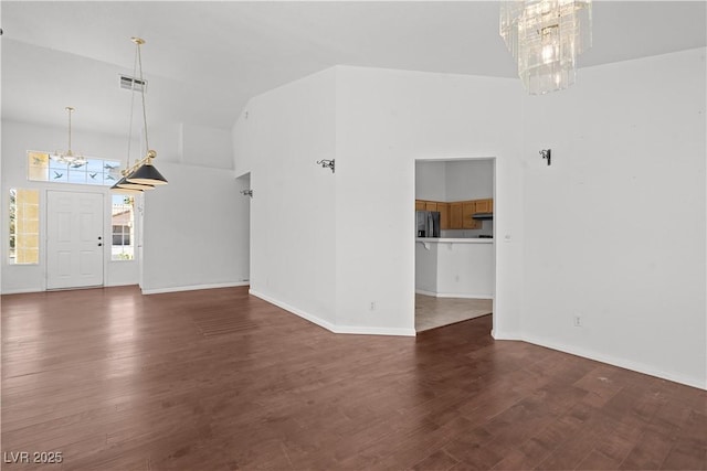 920 Serpentina Ave, Las Vegas, NV 89123 - unfurnished living room with a chandelier, wood finished floors, and a high ceiling